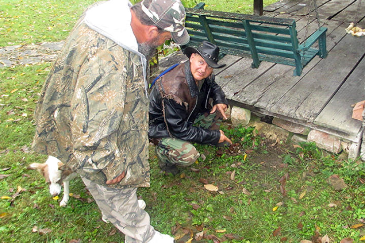 Ernie Brown, Jr., the Turtleman, and Neal James scout the perimeter of the house, searching for the critter.