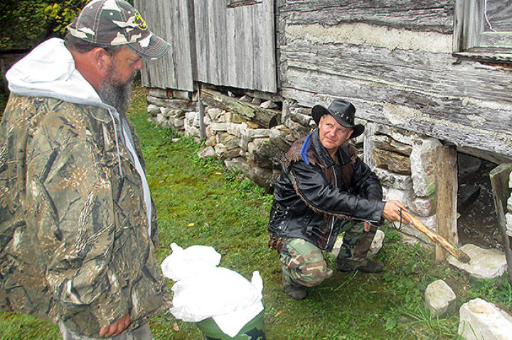 Ernie Brown, Jr., the Turtleman, and Neal James find the critter's entrance to where it dens.