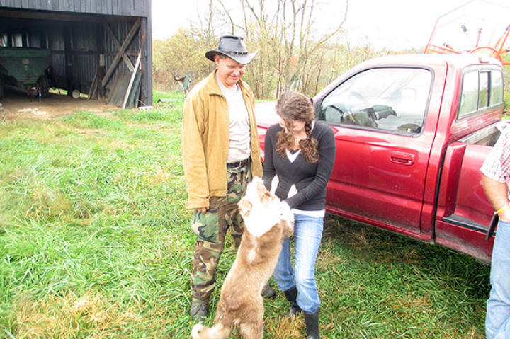 Farmer Cole Hensen plays with Lolly as Ernie Brown, Jr, watches.