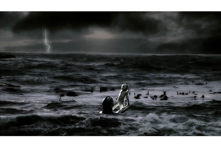 The mother holds her new born out of the water as it takes its first breath.