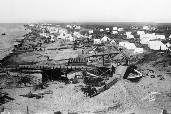 Within months, a tent city grew up around the gold deposits as thousands flocked north to reap the bounty. By 1900, when this photograph was taken, the population had exploded to over 20,000 with many of the new miners coming from the already overcrowded Klondike gold fields.