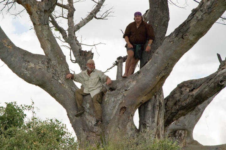 Getting some elevation on the first dry spot with trees they can reach, Cody and Dave use this vantage point to scan for an even bigger expanse of land that has a better chance of providing survival necessities.