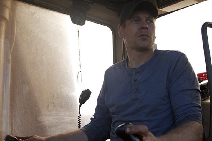 Co-owner Shawn Pomrenke mans the controls of the barge's CAT 320 excavator.