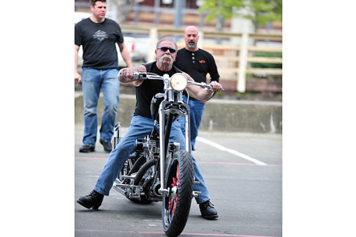 Senior with Jason Pohl and Mike Ammirati looking on rides the Deadliest Catch Bike to its reveal.