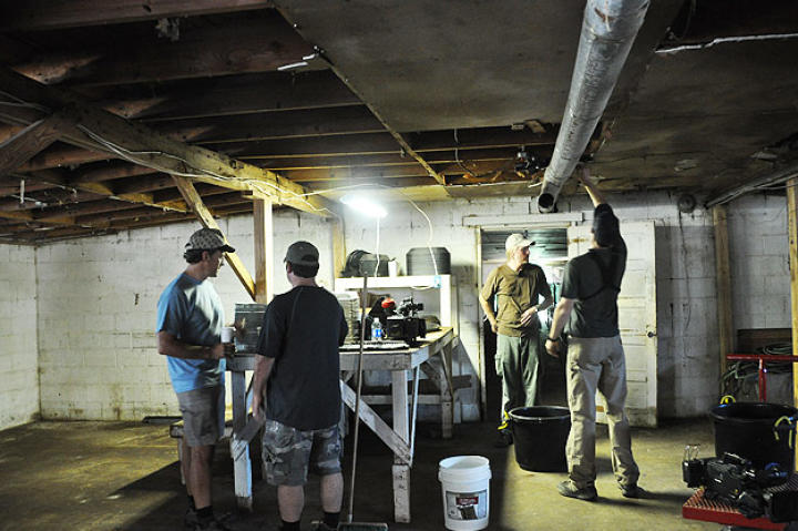 Doug Glover and Troy Paff set up the first interior shot at Ghann's Cricket Farm, while Mike Rowe and Dave Barsky consult.