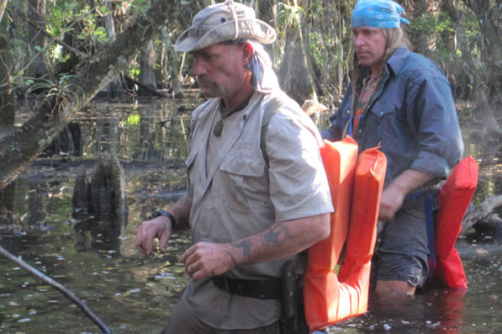Cody and Dave move cautiously through the dark, danger-laden waters. With his bare feet and legs, Cody admits to being way out of his comfort zone, but Dave once hunted reptiles in these swamps and feels right at home.