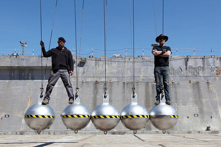 Jamie Hyneman and Adam Savage perch atop giant steel balls. (We'll spare you the jokes.)