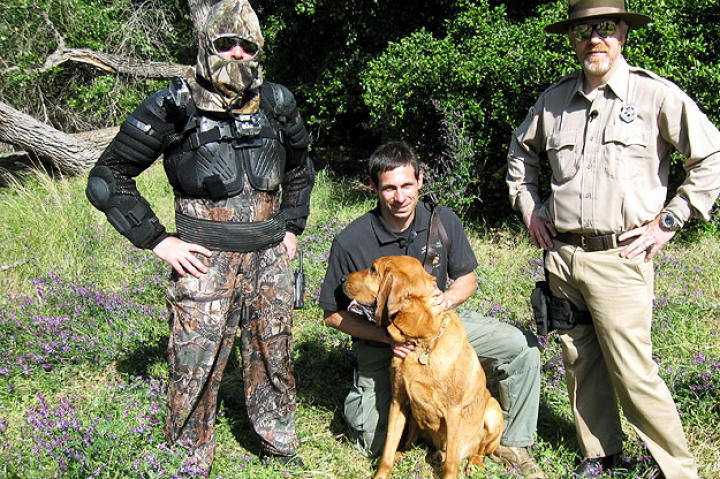 In "Hair of the Dog," Jamie Hyneman and Adam Savage — here with Morgan and his handler Matt — revisit a myth they've tried once before: Can an escaped convict really outsmart and outrun his pursuers?