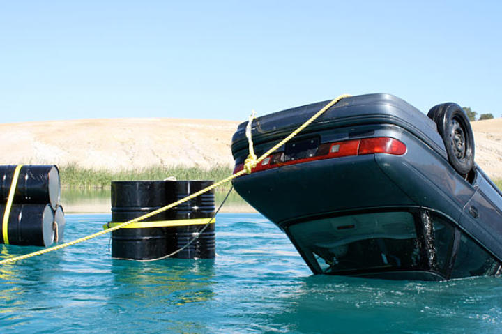 With Adam Savage inside, the upside-down car begins to sink.