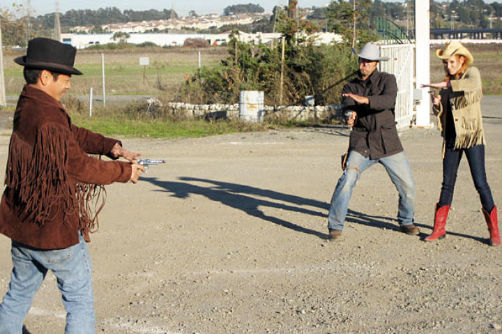 In the movies the bad guy drops his gun, and then the good guy easily blasts it out of reach. But can this trick shot really shoot a gun along the ground? Grant Imahra, Tory Belleci and Kari Byron suit up to see.