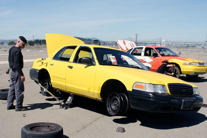 While Adam Savage settles on manhole covers as his flat-tire replacement, Jamie Hyneman removes his tires altogether, choosing to drive on the steel rims.