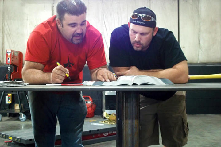 Vinnie DiMartino and Paul Jr. pore over designs.