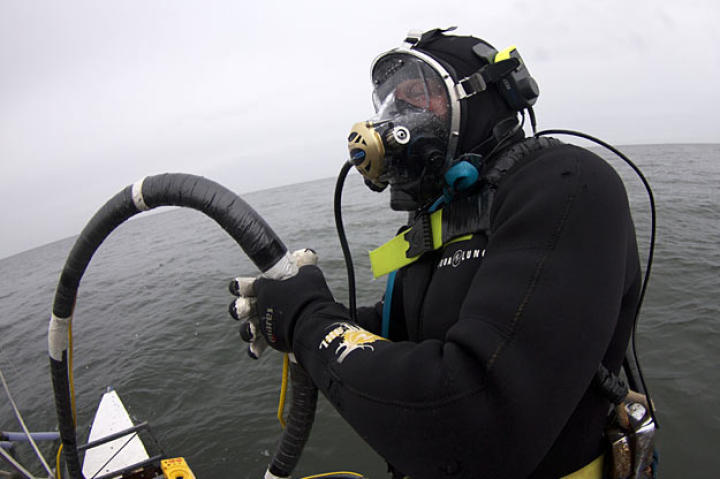 Holding his air hose to keep it clear during the dive, Scott gets ready to enter the water.