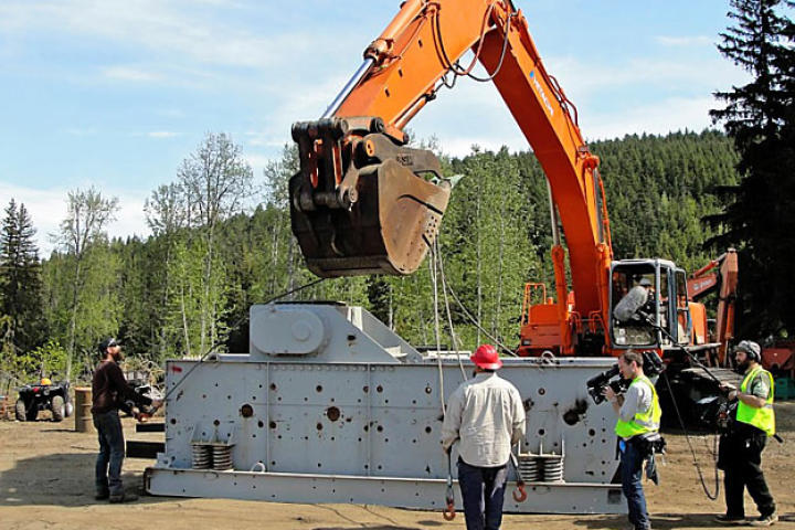 A camera and sound team catches the action as Todd and Dorsey secure the cables used to raise the shaker.