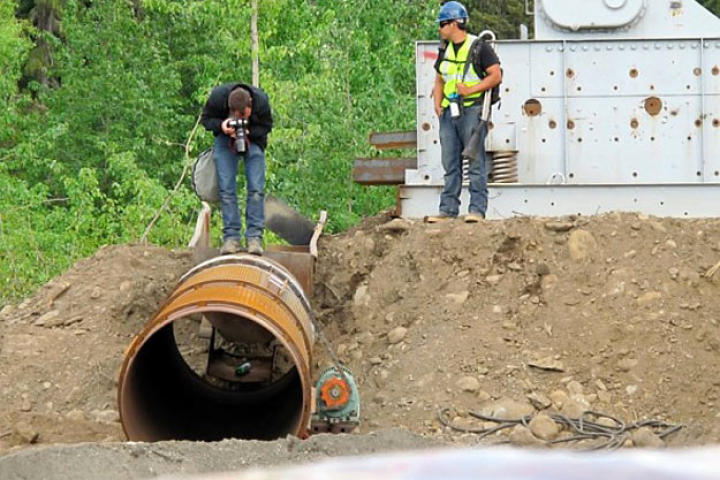 Photographer Paul Kirsop gets a close-up of the newly installed trommel while Safety Supervisor Pattrick Price keeps an eye out for bears. About the only support that the production crew provided for the miners was to team up on security measures to keep everyone safe.