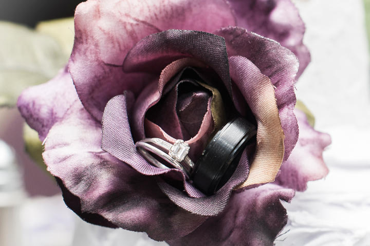 Angi chose a purple and black color scheme for her Friday the 13th nuptials. In this flower, you can see the couple’s wedding rings.