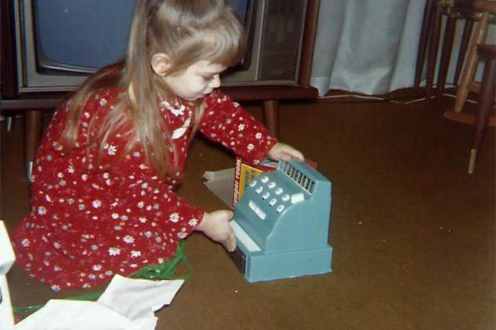 Theresa unwraps a toy register on Christmas day.