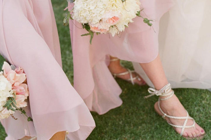 Bridesmaids in blush show off their bouquets and sandals.