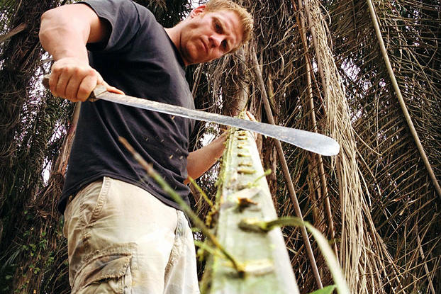 George uses a machete to get through the tough jungle.