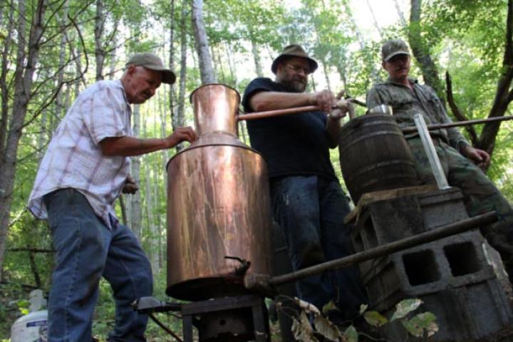 Jeff, Jim Tom and Mark fix a still out in the woods.