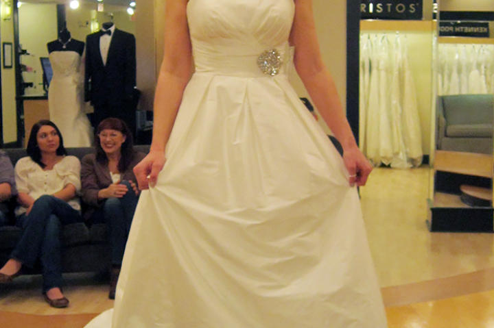 An architectural ivory ball gown with pleated neckline and structured skirt gets a boost of formality in ivory.