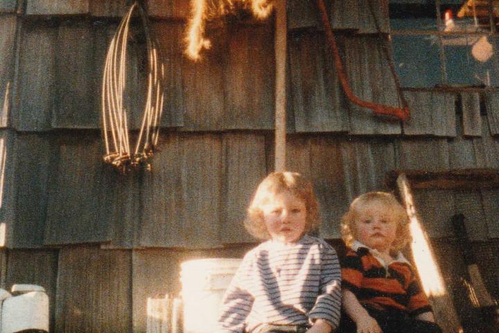 Matt and Bam Bam sit in front of their old cabin as babies. Look at those blonde curls!