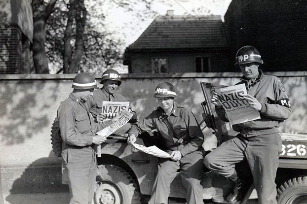 Four MPs take a break along a German road to read the best headline to date in the