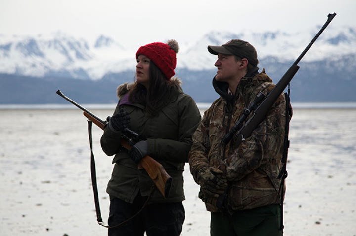 Atz Lee and Jane look up towards the coastal bluffs, in search of a bear emerging from a winter's den.