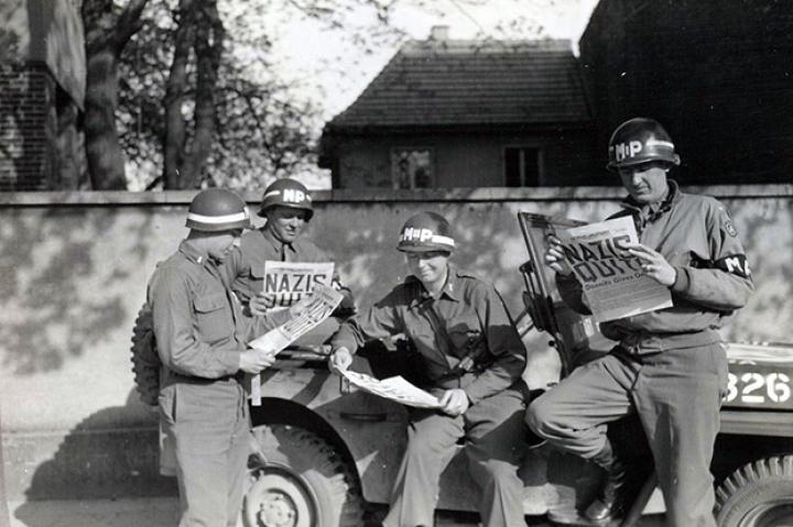 Four MPs take a break along a German road to read the best headline to date in the