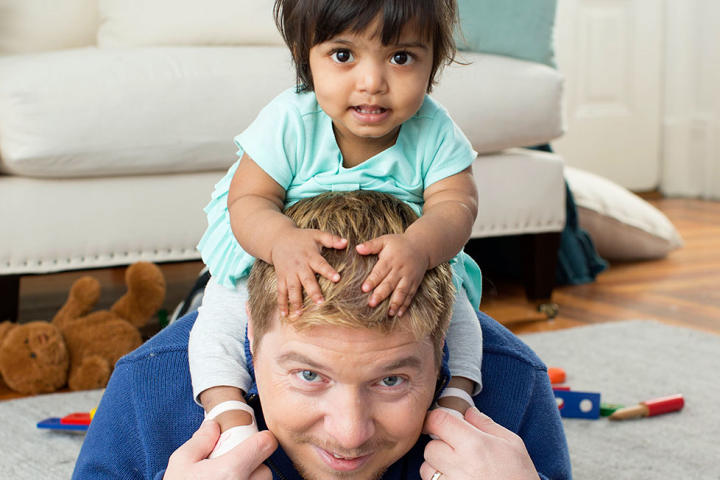 Zoey happily sits on Dad's shoulders.