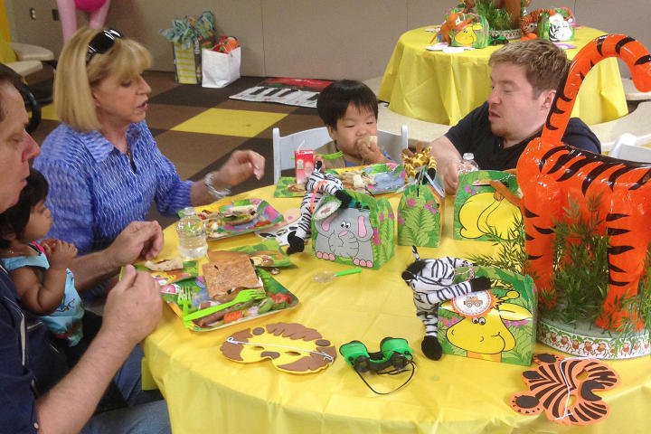 The family gathers around the birthday decorations to decide on a plan of action before hanging all the party decor.