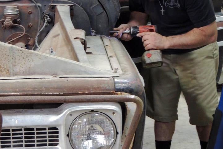 Dustin DeLeon works on the hood of the 1965 Chevy C-10 pickup truck back at the garage.