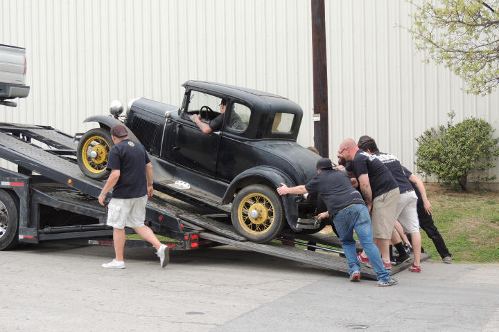 Tony Taylor observes as KC Mathieu, Mike Coy, Dustin DeLeon and several other Gas Monkies help unload the 1931 Model A.
