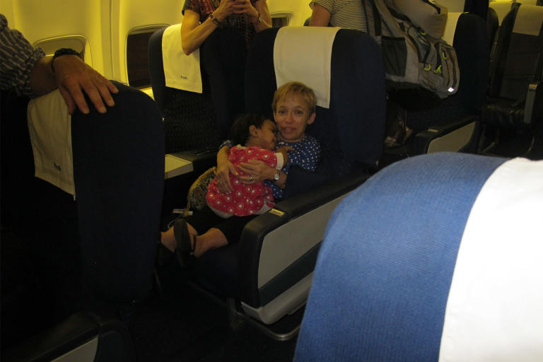 Jen comforts an upset Zoey on their flight to New Delhi.