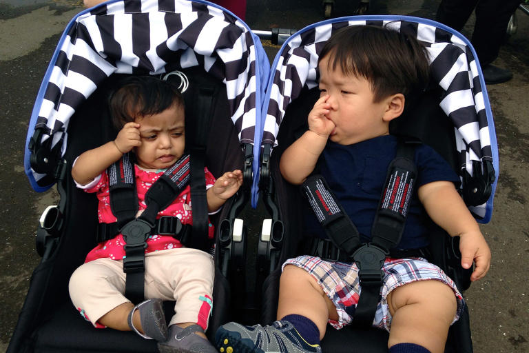 Zoey and Will sneak in some sibling bonding time in their strollers.