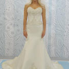 A chic trumpet silhouette makes the bride look even longer and leaner with beadwork on the bodice.