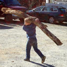 One of the Bates boys hauls a branch across the yard.
