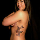 Ami tattoos a hummingbird, butterfly and flowers to symbolize a family.