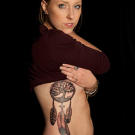 Tim Hendricks tattoos a dreamcatcher with on Emily.