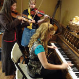 Tori and Erin Bates, accompanied by their violin teacher.