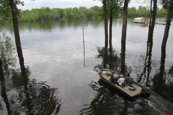When living in the bayou, boat transportation is crucial. Here, a realtor takes potential homebuyers from one house to the next by water.