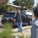 Doug Hopkins gestures towards fellow buyer John Ray during a housing auction.