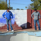 John Ray and Jace Johnson look at a pool in poor condition at a newly purchased property.