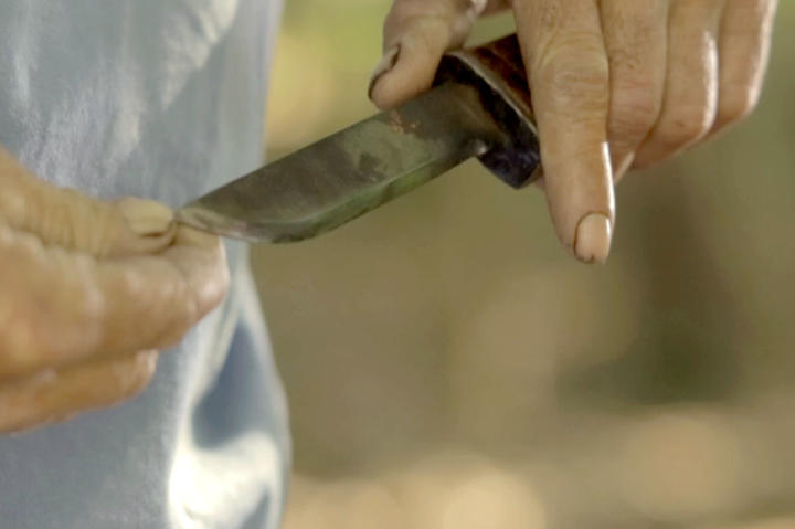 Eugene inspects one of his handmade knives.