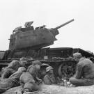 Soldiers of the 3rd SS-Panzer-Division Totenkopf (skull) resting next to a destroyed Soviet tank T-34. Even disabled it can provide cover.
Watch