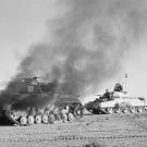 A British Crusader tank passes a burning German Panzer IV tank during Operation Crusader, the successful operation to lift the siege of Tobruk in Libya at the end of 1941.