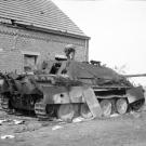 Inspecting an out of commission Panzer in Normandy. Notice the hole just above the second-to-last wheel.
Watch video of the