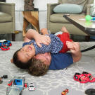 Bill and William play around while mom is preparing a grocery list. |