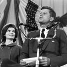 Jackie looks on as her husband delivers a speech.