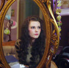 Emily sits at her dressing table to prepare for the day ahead. She wears faux lashes, special contact lenses and long wigs to enhance her doll-like appearance.
